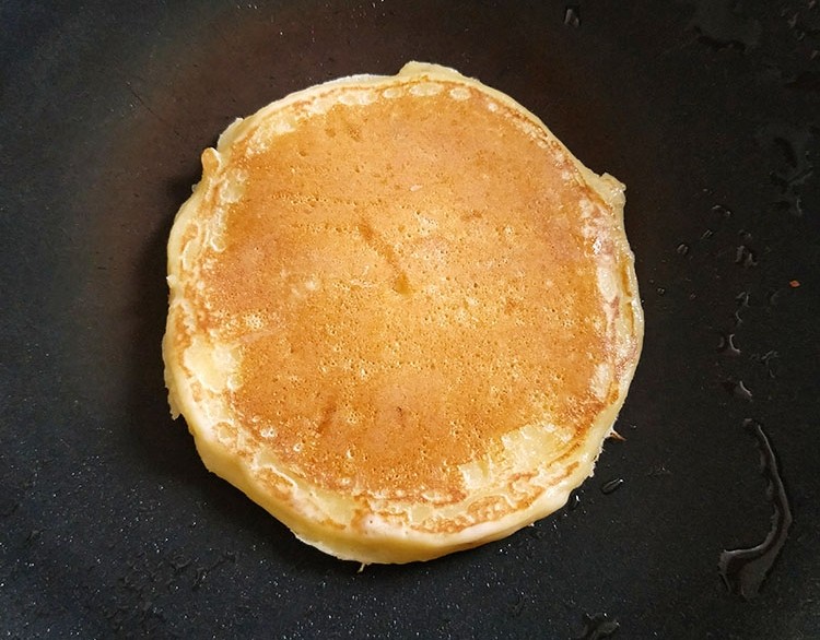 香蕉松饼,中小火，用小勺子盛一小勺面糊，等到表面有小气孔的时候，大约30S就可以翻面了，煎至两面微黄，出锅