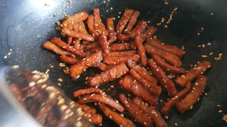 香辣里脊肉条 新文美食,倒入肉条快速炒均匀,加入鸡精调味儿翻炒均匀即可出锅。