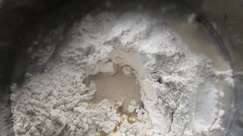 意式烤肠披萨,饼坯所有材料放入盆中,酵母,糖,盐分开放置,避免影响酵母活性,影响发酵。
