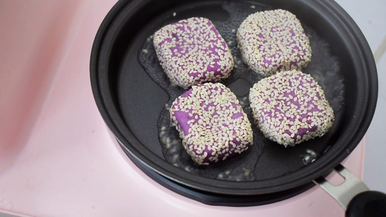 奶香紫薯饼,平底锅烧热,再放入紫薯饼,两面先煎至定型,再撒上1勺水,盖上锅盖煎至水干