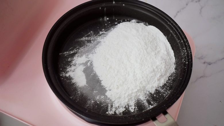 红糖奥利奥雪媚娘,糯米粉放入平底锅中小火加热,炒至糯米粉变成微黄色就可以了