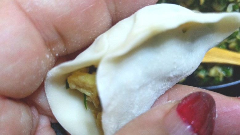 鸡蛋虾皮韭菜饺子,先把中间捏住,在把一边一点一点的捏在一起,在捏另一边。