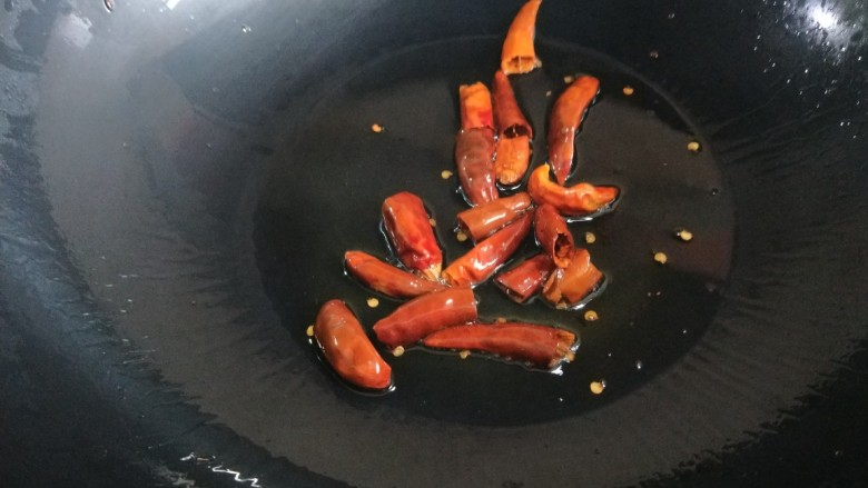 香辣里脊肉条 新文美食,在加入辣椒炒出辣油,倒入孜然粉,芝麻,辣椒粉。