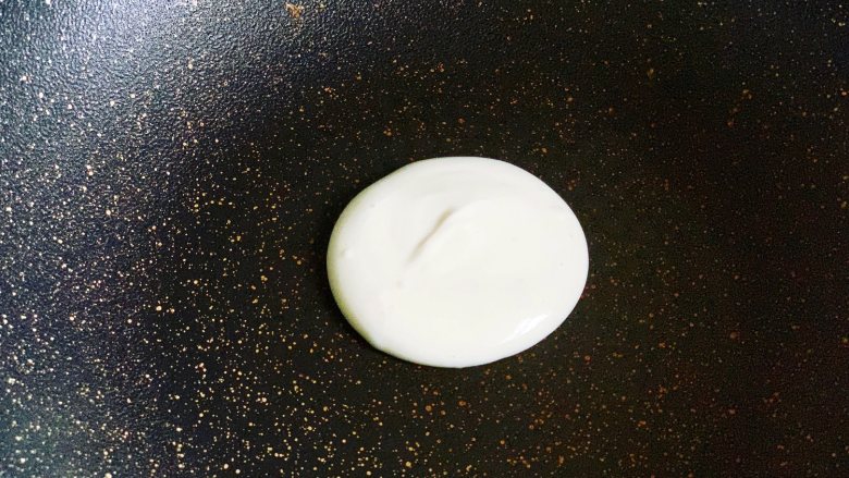 豆沙馅铜锣烧,平底锅最小火预热2分钟,不需要放油,然后用勺子舀入一勺面糊,小火加热。