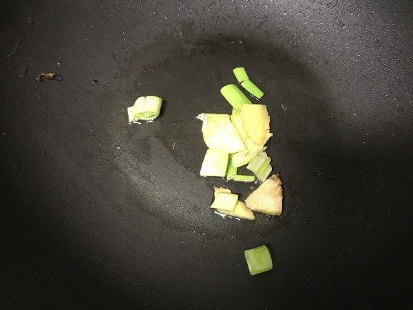 东北肉末烧茄子,留少许底油,烧热后放入葱姜蒜末爆香。
