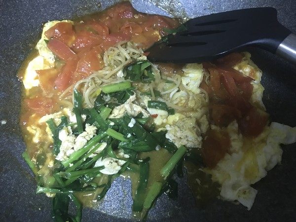 素烩饼,倒入鸡蛋液,炒至凝固后推到一边,下入其他菜炒半熟。