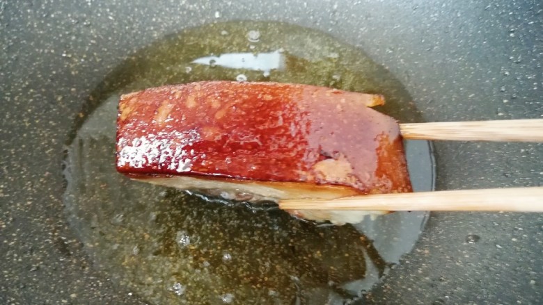金牌天津扣肉,五花肉用厨房用纸吸干表面多余的水分,肉皮朝下,炸至金黄色,肉皮暴起后捞出备用。