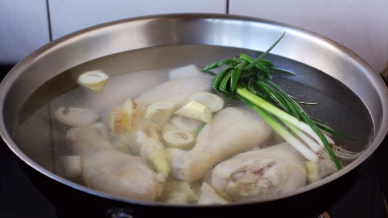 春笋海参煲鸡腿汤,大火置锅,温水或者开水放入春笋和鸡腿、小香葱、姜。