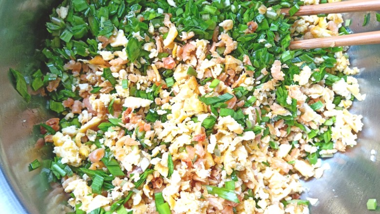 薄皮虾米鸡蛋韭菜盒子,给韭菜中倒入熟油搅拌均匀,再放入鸡蛋和虾米