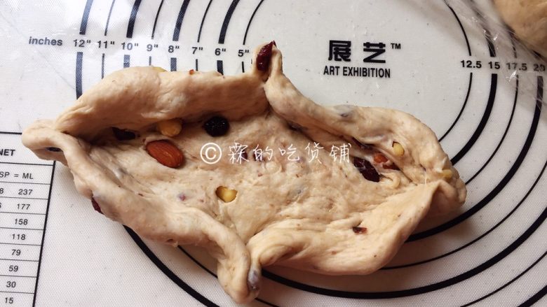 全麦蔓越莓坚果软欧,随后用手轻轻按成椭圆形,捏出四个角来。