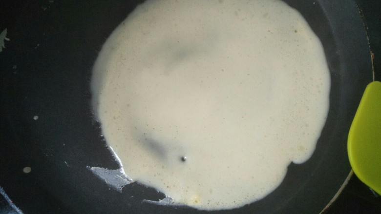 水果奶油卷,平底锅加热转小火,放入一勺面糊自然摊圆。
