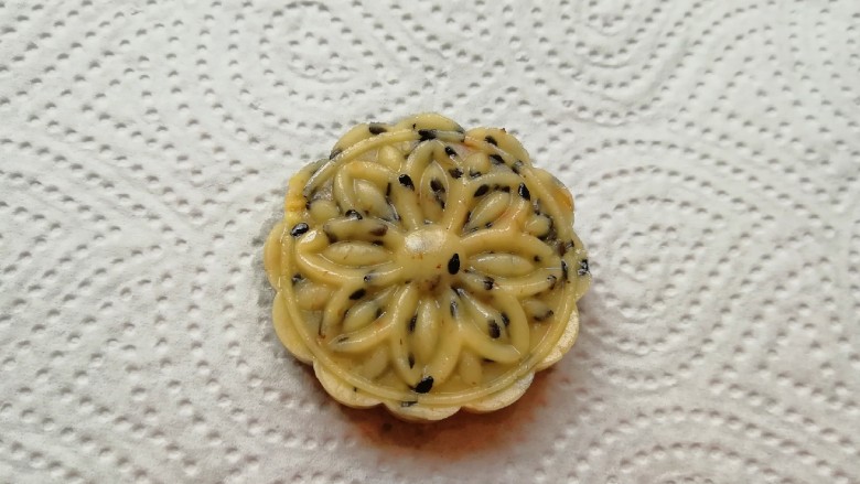 芝麻核桃酥,将搓好的小圆球放入月饼模具里面,压成带有花纹的芝麻核桃酥。