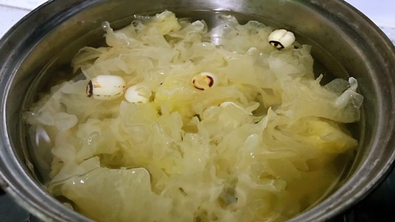银耳莲子羹,银耳和莲子放入锅中,加清水没过银耳,水要一次性加足够,留些蒸发的空间出来,水开后转成小火慢慢炖,这样煮出来的莲子银耳羹软烂、浓稠。银耳出胶的小秘方一个是银耳越小越容易出胶,还有一个是水不要加得太多。