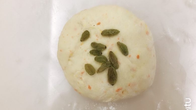 胡萝卜橙香蜂蜜面包,翻面,放上葡萄干,也可以不放像包包子一样包起来,收口捏紧朝下