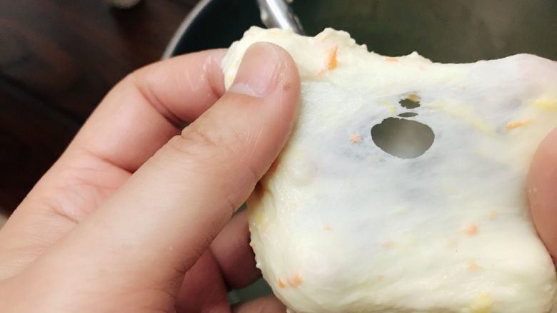 胡萝卜橙香蜂蜜面包,打至8成筋,既可以扯开较薄的膜,但是破洞有轻微锯齿状