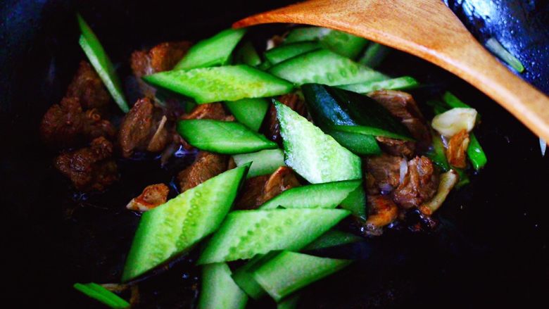 黄瓜牛肉粉嫩扯面,看见牛肉块和调料翻炒均匀后,倒入黄瓜片。