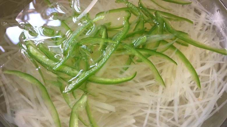 剁椒土豆丝,捞出,然后直接放入冷水中浸泡,这样凉拌出来口感更爽脆。青椒也放入沸水中30秒就可以捞出放入冷水中