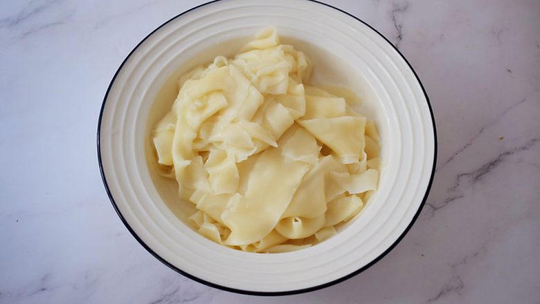 饺子皮油泼面,再捞出面条过凉水再捞出放入碗中,青菜先放另外的盘中备用