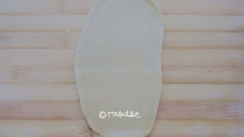 又卷烧饼(家庭版),然后用手按扁面团,擀成牛舌状。