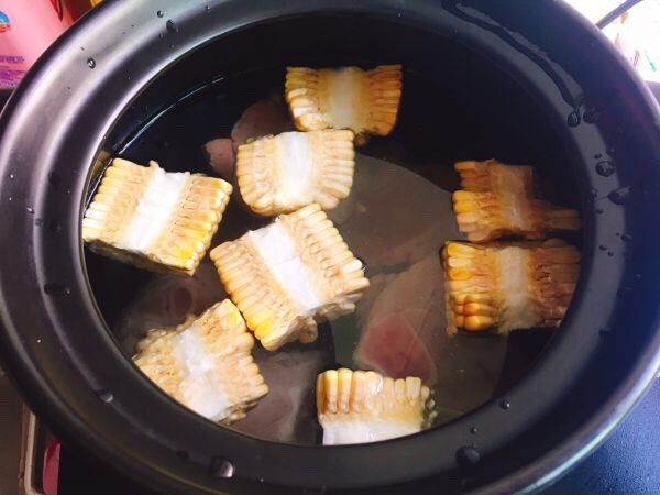 鲜味什锦火锅,取一个砂锅,放入大猪骨、玉米、清水,盐