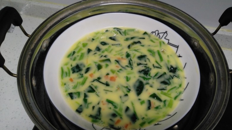 菠菜蒸蛋,加入盐、<a style='color:red;display:inline-block;' href='/shicai/ 25'>胡萝卜</a>碎搅拌均匀，水开后放入蒸锅。