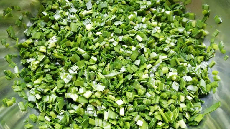干拌饺子,控过水的韭菜切碎放入盆里,加入熟油搅拌均匀。