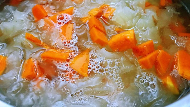 银耳南瓜羹,银耳煮20分钟后加入处理好的南瓜继续煮20分钟,中途可拿勺子搅动一下锅中。