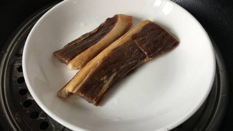 烟熏腊肉炒芹菜,腊肉在冷水里浸泡30分钟,清洗干净,把表皮的灰尘和烟灰都要处理干净,然后再浸泡30分钟,上锅直接蒸熟