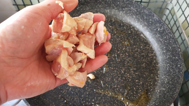 奶香南瓜鸡肉焗饭,热锅放入油,放入鸡丁,炒至微微焦黄。
