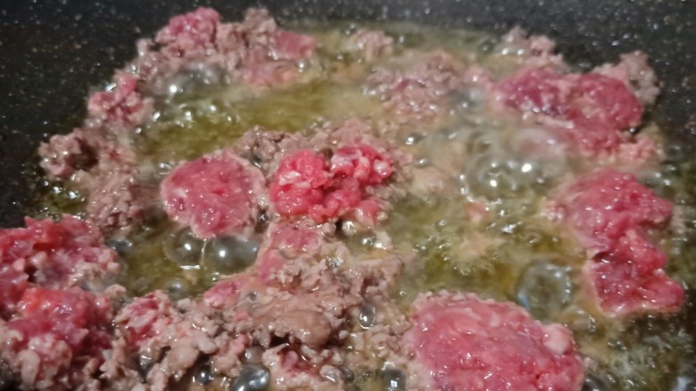 草籽肉末炒年糕,锅肉加适量的菜籽油,下蒜泥炒香再下牛肉翻炒。