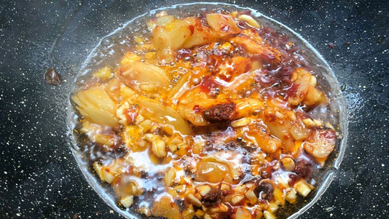 香辣牛蛙,热锅放入适量油,烧至6成热,放入郫县豆瓣酱小火炒出红油,再加入泡姜和蒜末炒出香味。