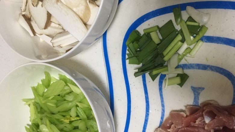 芹菜杏鲍菇炒肉,杏鲍菇切片,芹菜切丝,肉切丝;蒜切段。