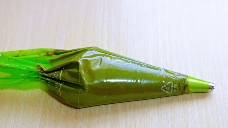 巧克力奶油泡芙,将面糊装入裱花袋,(先装入裱花嘴,再装面糊哈)用刮板将面糊往前推,如图。