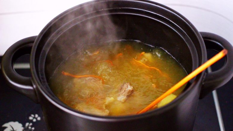 虫草花山药炖排骨,大火煮沸后,用勺子撇去浮末。
