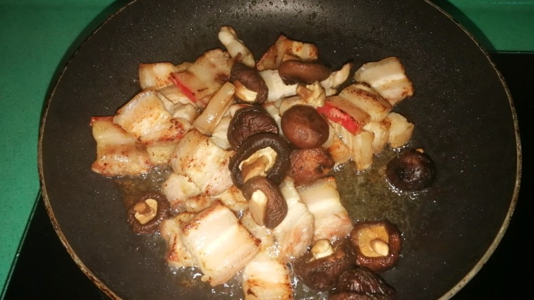 五花肉焗南瓜,放入泡好的香菇,翻炒出香味