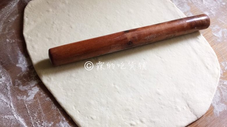 豆沙白玉卷,案板上撒上干粉,发酵好的面团倒上去揉透,然后用擀面杖擀成一张长方形的面片。