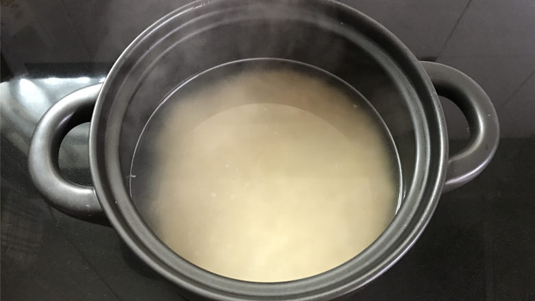 牛奶香蕉燕麦粥,把浸泡好的燕麦放入砂锅中,加入热水。
