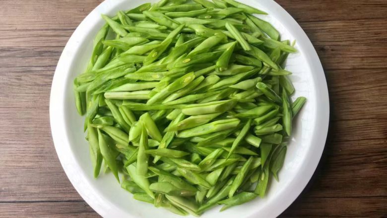 四季豆炒蛤蜊肉,<a style='color:red;display:inline-block;' href='/shicai/ 69'>四季豆</a>清洗干净,用刀切成斜块,这样更容易入味,全部切好装入盘里待用。