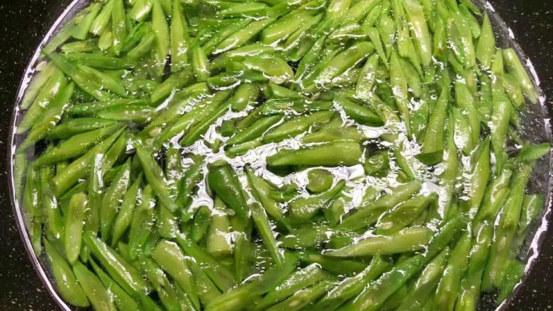 四季豆炒蛤蜊肉,热锅放入适量油,烧至8成热,把蒜末放入炒出香味。
