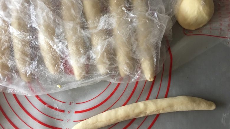 肠仔包,卷起来捏紧收口,做面包过程中所有的收口处一定一定要多捏合几次,否则烤制过程会开裂,盖保鲜膜静置10分钟