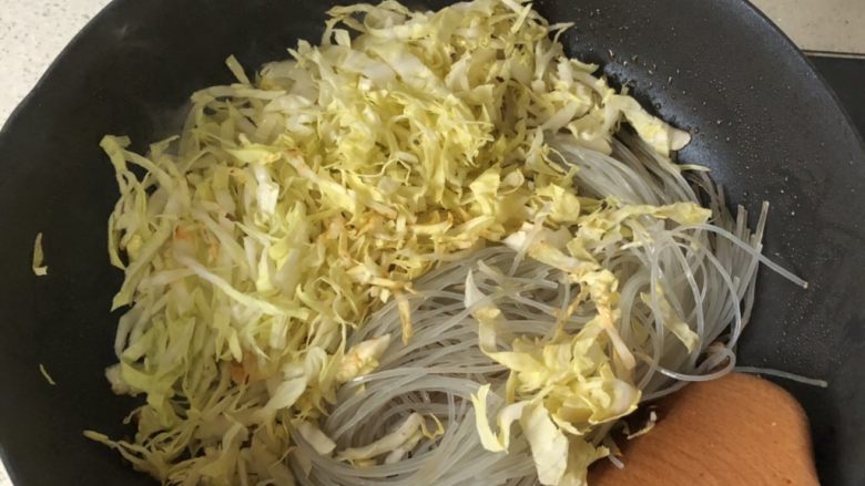 肉末白菜粉丝,倒入粉丝和包菜,炒匀。喜欢包菜清脆口感的,可以晚点放