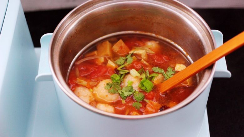 虾滑番茄豆干汤,大火煮沸后即可关火,撒上香菜段和少许蒜苗叶即可。