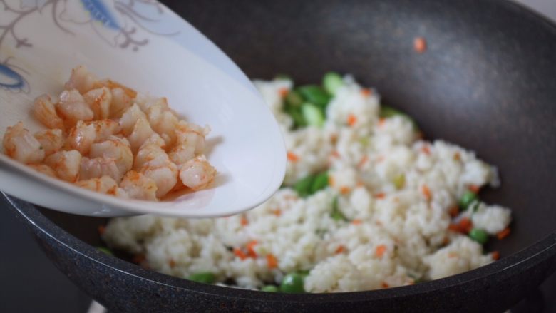 芦笋虾仁焗饭配冬阴功风味蒸烤鸡胸,放入炒好的虾仁，翻炒均匀。