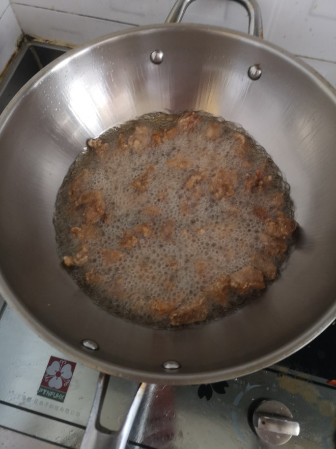 熘肉段,起锅烧油,肉块逐个单次下入油锅中,炸至两面金黄,捞起备用