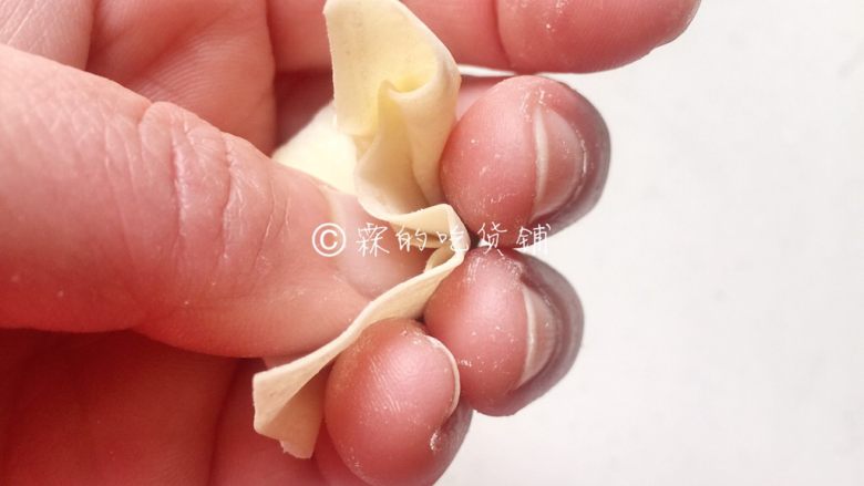 上海三鲜小馄饨,再一气呵成,依次捏压食指、中指、无名指、小指处的皮子,最后抽出大拇指,完成。