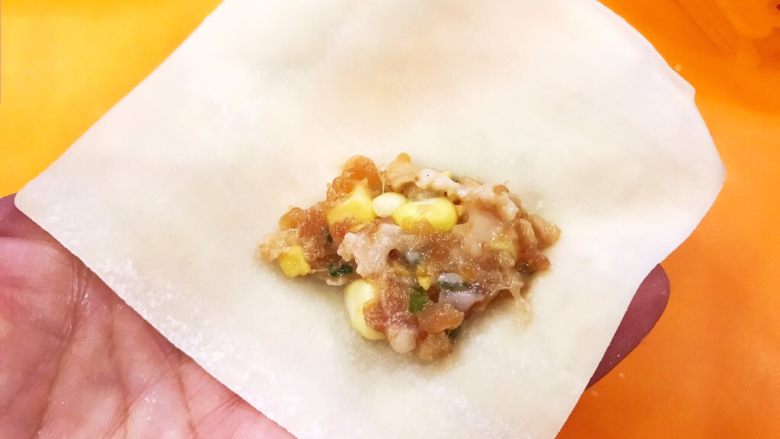 猪肉甜玉米馅抄手,取一片面皮,加入1小勺猪肉甜玉米馅料