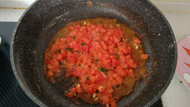 家常菜--西红柿炒鸡蛋,锅内再次倒入食用油 放小葱炒香(稍微留一点最后装饰用)倒入提前切好的西红柿丁 翻炒出汤汁(这也是决定汤汁粘稠的关键)如果觉得太干可以加一点点水。