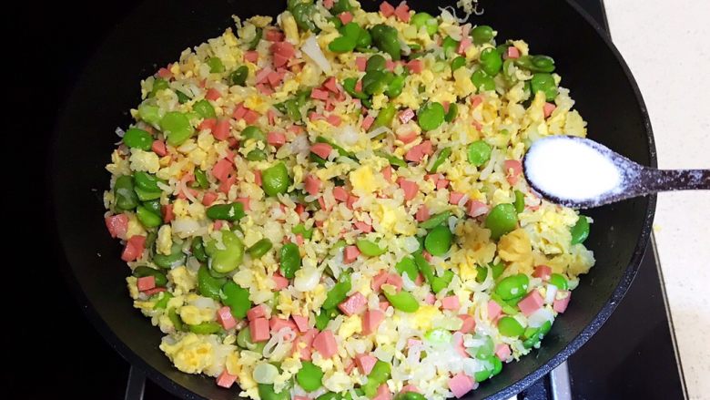 蚕豆火腿肠炒饭,翻炒均匀,加入精盐调味
