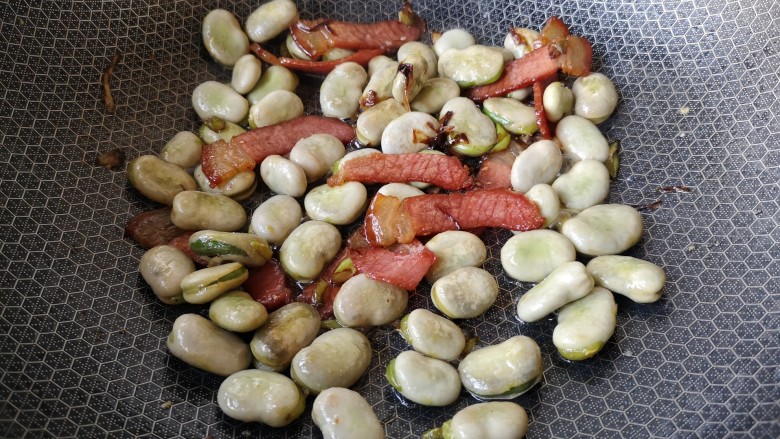 葱油腊味鲜蚕豆,大火翻炒至糖,盐,鸡精都融化,蚕豆表面有金黄色印记,皮微微发皱。