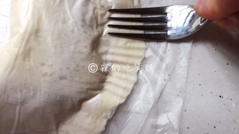 飞饼版 快手香蕉派,用叉子,稍稍用点力,隔着塑料纸刻出花纹(有塑料纸在,面皮就不会粘在叉子上)。